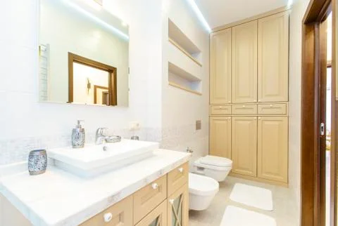 Bathroom with elegant rectangular washbasin, toilet and shower. Mirror with l Stock Photos