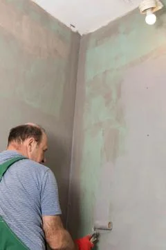 In the bathroom, a general construction worker applies moisture insulation using 写真素材
