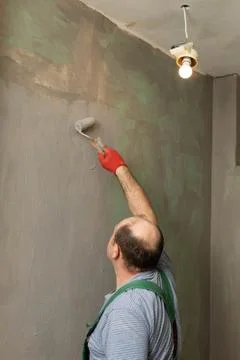 In the bathroom, a general construction worker applies moisture insulation using Stock-Fotos