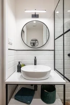 Bathroom interior with black frames, round mirror and classic white tiles Photos