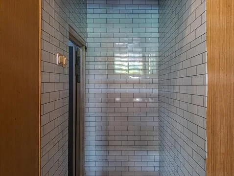 Bathroom interior featuring subway tile and wooden trim in a simple home de.. Stock Photos