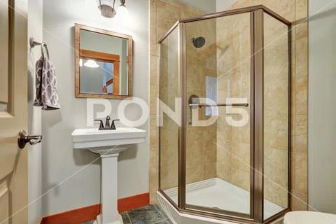 Bathroom interior - glass shower with beige tile wall trim and washbasin stand. Stock Photos