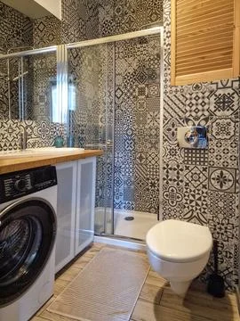 Bathroom interior with washing machine, shower cabin, toilet and sink Stock Photos