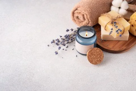 Bathroom items with crafted bars of soap, towel and aroma candle on wooden tr Stock Photos