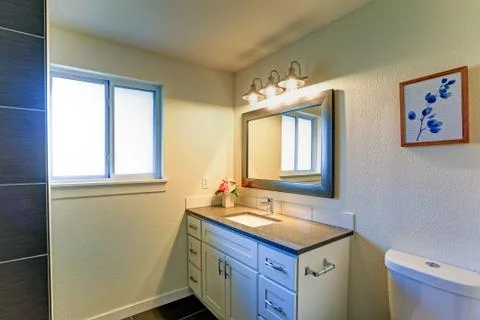 Bathroom nook features white vanity cabinet with brown color granite top fram Stock Photos
