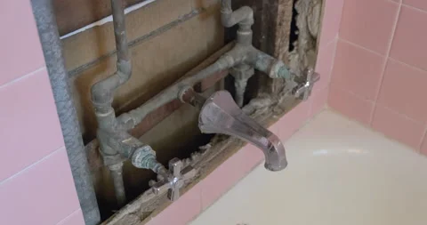 Bathroom renovation with opened tile wall, Old plumbing fixtures - 4K Prores 422 Stock Footage 241335932