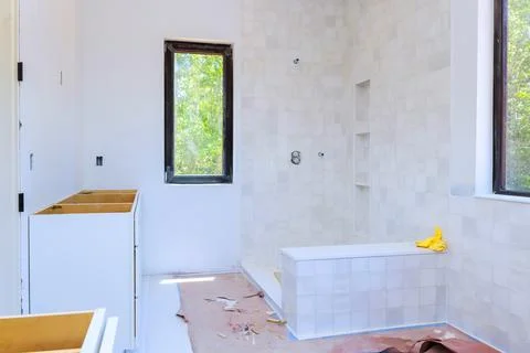 Bathroom renovation in progress empty cabinets shower area Stock Photos