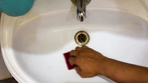 Bathroom Sink Cleaning Routine with Hand and Scrub Pad Close Up Stock Footage 337970079