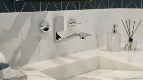 Bathroom sink made of textured marble equipped with shiny faucet with original Stock Footage 273832069