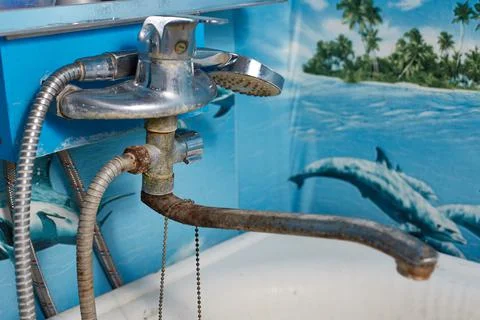 In the bathroom there is an old bathtub with a rusty faucet rust and unsanita Stock Photos