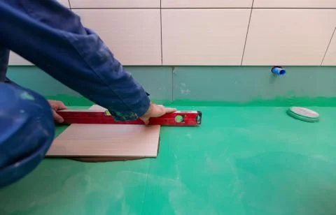 Bathroom tiles replacing. Caucasian worker is installing brand new ceramic tiles Stock Photos