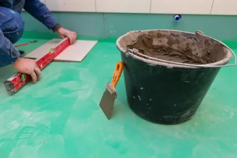 Bathroom tiles replacing. Caucasian worker is installing brand new ceramic tiles Stock Photos