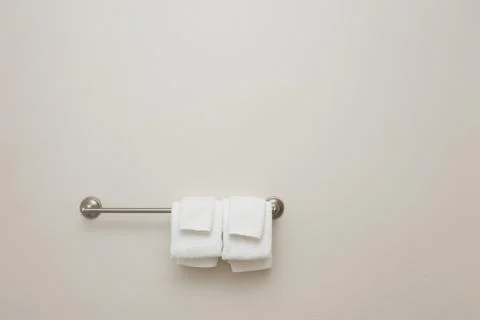Bathroom towel set on rack, empty wall space Stock Photos