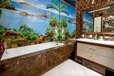 A bathroom with a tropical theme, featuring a large bathtub and a mirror Stock Photos
