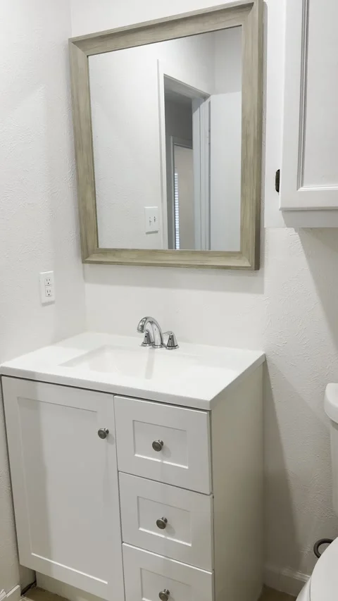 Bathroom Vanity Sink and Mirror in Empty Home Stock Footage 345844944
