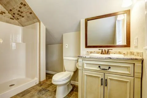Bathroom with vaulted ceiling. vanity cabinet and mirror Stock Photos
