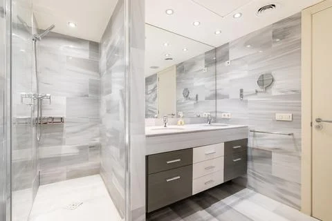 Bathroom with wall separating washbasin with vanity unit from shower Stock Photos