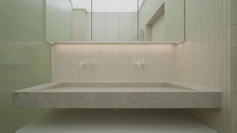 Bathroom washbasin unit with two wall mounted faucet tap mixers made of tile. Vídeos de archivo 335540835