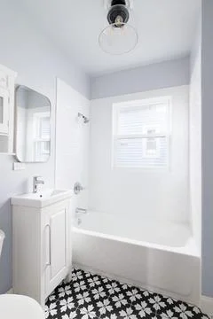 A bathroom with a white cabinet and pattern tile floor. Stock Photos