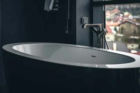 Bathtub in the interior of the bathroom with a window. Stock Photos