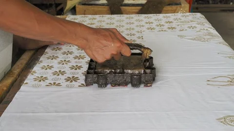 Batik stamp process copper stamps hot wax create batik motif onto fabric Stock Footage 143766926