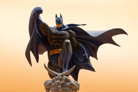 Batman action figure standing dynamically on a dark gargoyle. Studio shot. Stock Photos