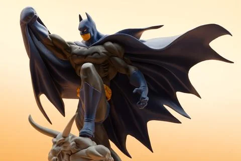 Batman action figure standing dynamically on a dark gargoyle. Studio shot. Stock Photos