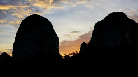 Bats fly out of the cave in the mountains at sunset. Stock Footage 112063137