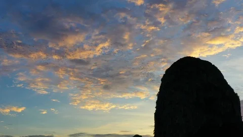 Bats fly out of the cave in the mountains at sunset. Vidéo 112063632