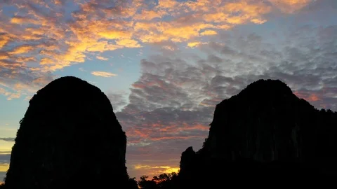 Bats fly out of the cave in the mountains at sunset. Stock Footage 112063772