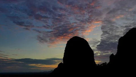Bats fly out of the cave in the mountains at sunset. Stock Footage 112397079