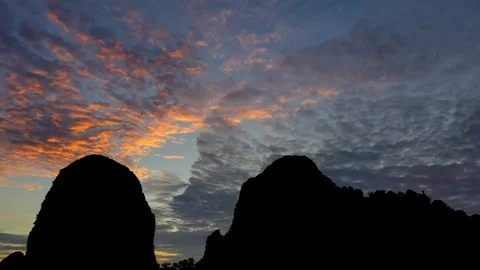 Bats fly out of the cave in the mountains at sunset. Stock-Footage 113989061