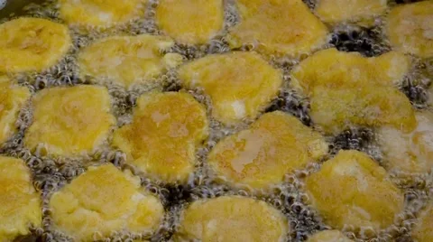 Batter fried chicken nuggets meat are being cooked deep fried in hot boiling pan Stock Footage 58942653