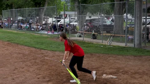 Batter gets base hit during small town coed soft ball tournament Stock-Footage 202805539