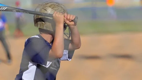 A batter makes a base hit while playing in a boys little league baseball game. Stock Footage 70464273