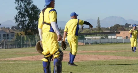 With batter ready, male pitcher lifting leg on mound, releasing baseball toward Stock Footage 334840922