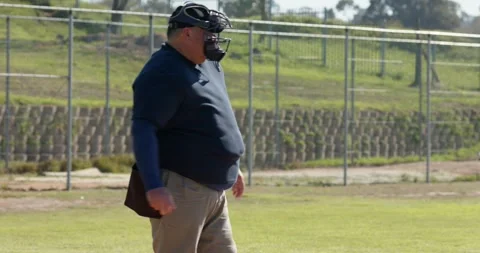 Batter swinging bat at plate on pitch, catcher securing ball, umpire signaling Stock Footage 339413063