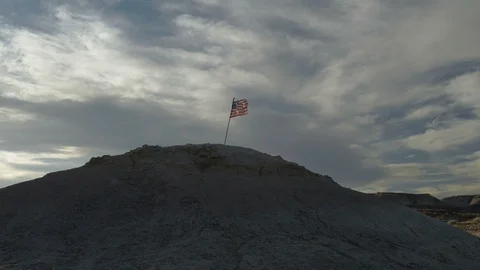 A battered American flag on top of a desert hill Stock Footage 112709829