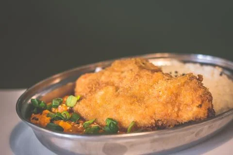Battered and deep fried chicken breast fillet and served with steaming white  Stock Photos