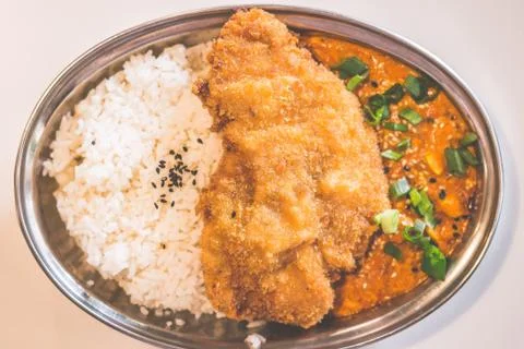 Battered and deep fried chicken breast fillet and served with steaming white  Stock Photos