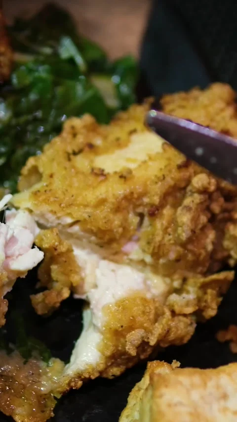 Battered baked chicken wings served with spinach on rectangular black plate 스톡 동영상 318729545
