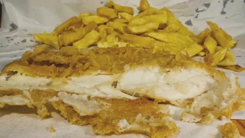 A battered fish and chips takeaway meal in paper wrapping. Vídeos de archivo 255850453