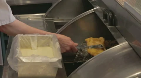 Battered fish being placed on hot plate Stock Footage 58091961