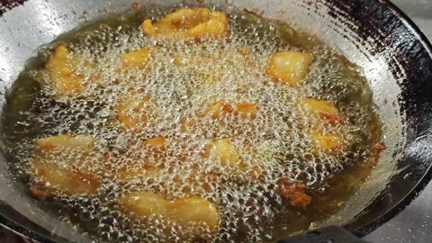 Battered fish pieces deep frying in a wok of boiling oil. Stock Footage 342690520