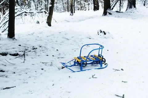 A battered sled in a clearing. Lost things in the snow in winter 库存照片