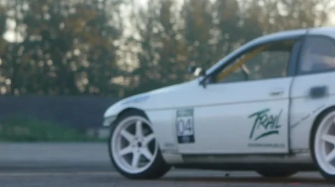 Battered white car pulls onto track during drift racing event. Stock-Footage 59761986