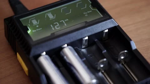 Batteries in the charger. Charge indicator. Video stock 130174103