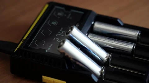 Batteries in the charger. Charge indicator. Video stock 130174603