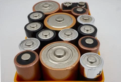 Batteries of different sizes and formats in a box, selective focus. Stock Photos