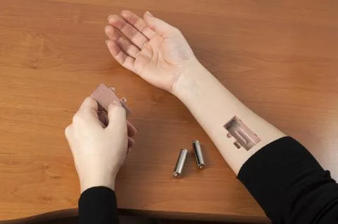Batteries inserted into a hand. Creative idea Stock Photos